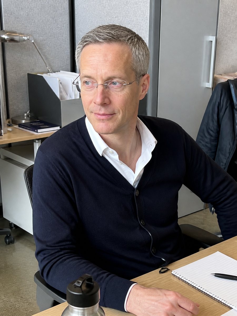 Tyson Asper at his office desk with a notebook